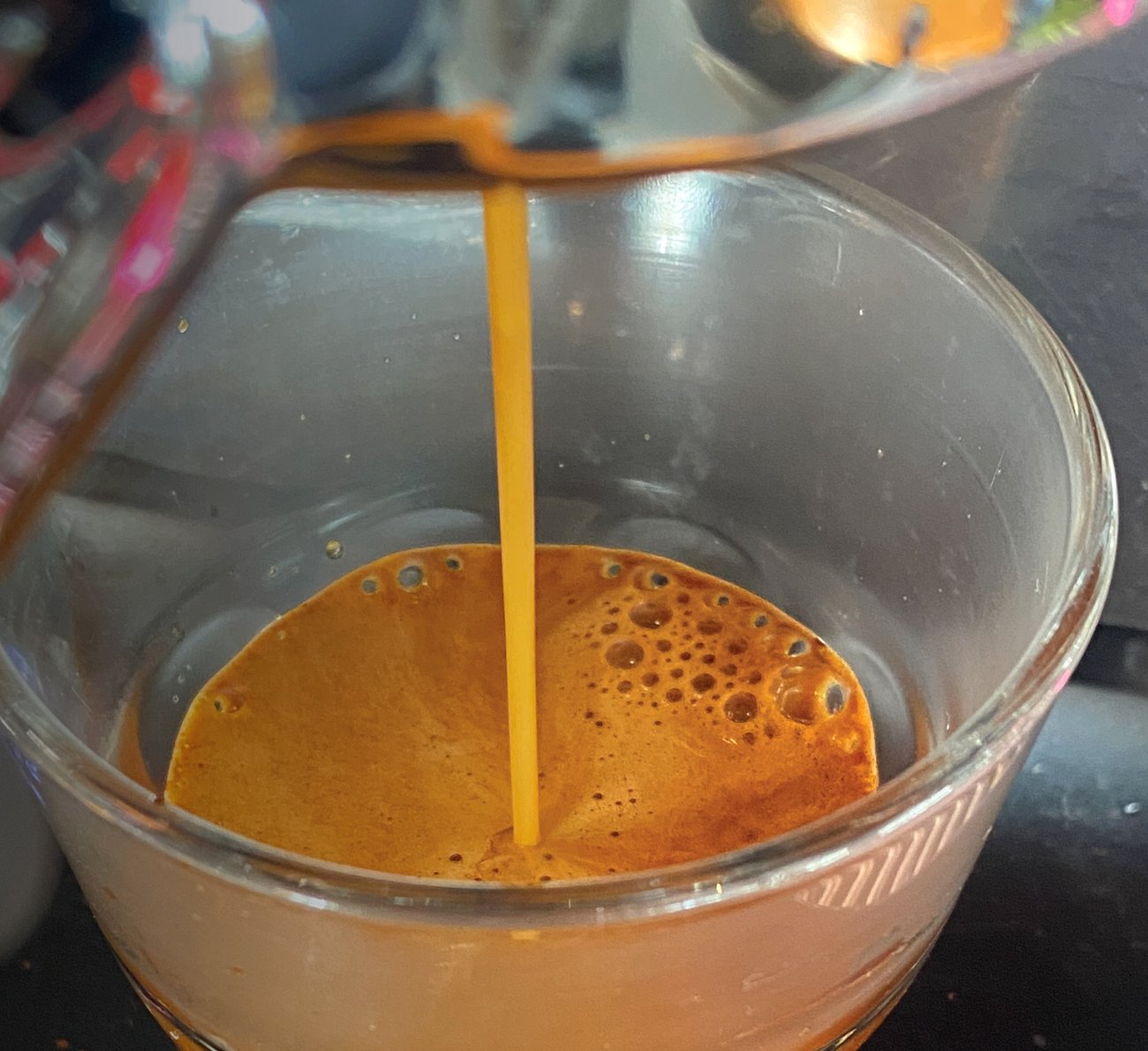 A shot of espresso pouring into a glass at The Coffee Can